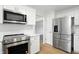 This modern kitchen features stainless steel appliances, white cabinetry and countertops at 13264 Penneagle Dr, Carmel, IN 46033