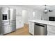 Bright kitchen boasts stainless steel appliances, white cabinets, quartz countertops, and an island at 13264 Penneagle Dr, Carmel, IN 46033