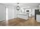 An open concept kitchen with stainless appliances, an island, a modern light fixture, and wood floors at 13264 Penneagle Dr, Carmel, IN 46033