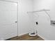 A simple laundry room with white walls, a metal shelf, and white door at 13264 Penneagle Dr, Carmel, IN 46033