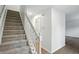 Carpeted stairs with white railing, leading to the upper level of the home with hardwood flooring at 13264 Penneagle Dr, Carmel, IN 46033