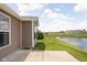 A peaceful backyard view featuring a pond, green lawn, landscaping, and back of home at 1418 Blackthorne S Trl, Plainfield, IN 46168