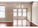Dining room features hardwood floors, neutral paint, a modern chandelier, and natural light from three windows at 1418 Blackthorne S Trl, Plainfield, IN 46168