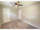 Neutral-toned bedroom featuring carpeted floors, multiple doors and an overhead ceiling fan with light at 1605 S Leland Ave, Indianapolis, IN 46203