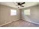 Bright bedroom featuring carpeted floors, neutral paint, and an overhead ceiling fan with natural light from two windows at 1605 S Leland Ave, Indianapolis, IN 46203
