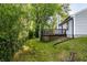 A landscaped backyard with green grass, trees and a wood deck at 1657 Park Terrace Ct, Indianapolis, IN 46229