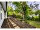 A serene backyard featuring a wooden deck, stepping stones, and lush greenery at 1657 Park Terrace Ct, Indianapolis, IN 46229
