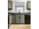 Updated kitchen with sleek, green cabinets, stainless sink, and modern black appliances at 1657 Park Terrace Ct, Indianapolis, IN 46229