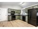 An eat-in kitchen featuring modern appliances, painted cabinets, laminate floors, and an open view of the living room at 1657 Park Terrace Ct, Indianapolis, IN 46229