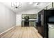 An eat-in kitchen featuring modern appliances, painted cabinets, laminate floors, and an open view of the living room at 1657 Park Terrace Ct, Indianapolis, IN 46229