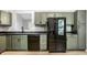 An eat-in kitchen featuring modern appliances, painted cabinets, laminate floors, and an open view of the living room at 1657 Park Terrace Ct, Indianapolis, IN 46229