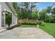 Beautiful backyard with stone patio, brick wall, landscaping, and mature trees on a manicured lawn at 1805 Wood Valley Dr, Carmel, IN 46032