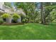 Expansive backyard with lush green lawn, privacy landscaping, and exterior deck at 1805 Wood Valley Dr, Carmel, IN 46032