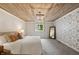 Stylish bedroom features wood-paneled ceiling and patterned accent wall at 1805 Wood Valley Dr, Carmel, IN 46032