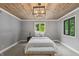 Cozy bedroom with natural light from two windows, complemented by wood paneled ceilings and soft gray walls at 1805 Wood Valley Dr, Carmel, IN 46032