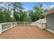 Large wooden deck with decorative white railing overlooking a lush, green backyard at 1805 Wood Valley Dr, Carmel, IN 46032