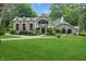 Charming home featuring lush lawn, manicured landscaping, stone accents, and architectural details at 1805 Wood Valley Dr, Carmel, IN 46032