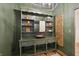 Elegant powder room boasts a custom green vanity, unique copper sink, and rustic hardwood flooring for a sophisticated touch at 1805 Wood Valley Dr, Carmel, IN 46032