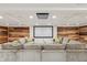 Home theater room with large sectional couch, projector screen, and wood-accent walls at 1805 Wood Valley Dr, Carmel, IN 46032