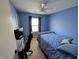 Cozy bedroom with blue walls, a ceiling fan, and a large window for natural light at 1823 Long Lake Dr, Greenwood, IN 46143