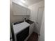Well-lit laundry room featuring side-by-side washer and dryer units with white cabinets at 1823 Long Lake Dr, Greenwood, IN 46143