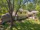 Charming home with a backyard surrounded by greenery, featuring a stone foundation and outdoor patio at 1930 Bechtel Rd, Indianapolis, IN 46260