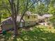 View of a home backyard with large trees surrounding, featuring a patio area with a grill at 1930 Bechtel Rd, Indianapolis, IN 46260