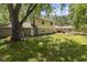 Expansive backyard featuring a stone facade house, mature trees, and a patio area at 1930 Bechtel Rd, Indianapolis, IN 46260