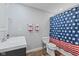Bathroom with patriotic shower curtain and decor, gray vanity and wood look flooring at 1930 Bechtel Rd, Indianapolis, IN 46260