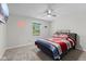 Cozy bedroom features a ceiling fan, a window for natural light, and carpeted flooring at 1930 Bechtel Rd, Indianapolis, IN 46260