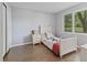 Nicely finished bedroom with wood floors, white trim, and bright natural light from the window at 1930 Bechtel Rd, Indianapolis, IN 46260