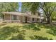Elegant home featuring stone detailing, lush green lawn, and mature trees adding curb appeal at 1930 Bechtel Rd, Indianapolis, IN 46260