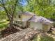Charming two-story home features a two-car garage and stone accents, complemented by mature trees and landscaping at 1930 Bechtel Rd, Indianapolis, IN 46260