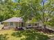 Inviting home with stone and siding exterior, surrounded by mature trees and a well-maintained lawn at 1930 Bechtel Rd, Indianapolis, IN 46260
