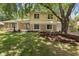 Beautiful home with stone accents, a manicured lawn, and mature trees providing shade and privacy at 1930 Bechtel Rd, Indianapolis, IN 46260