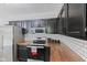 Updated kitchen features stainless steel appliances, dark cabinets, butcher block countertops, and subway tile backsplash at 1930 Bechtel Rd, Indianapolis, IN 46260