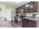 Modern kitchen featuring stainless steel appliances, dark wood cabinets, and light-colored granite countertops at 19555 Kailey Way, Noblesville, IN 46062