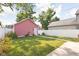 Lush backyard with a well-manicured lawn, white fence, and a detached garage at 2015 N College Ave, Indianapolis, IN 46202