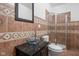 Unique bathroom featuring tiled walls, glass bowl sink, dark wood vanity and a glass enclosed shower at 2015 N College Ave, Indianapolis, IN 46202