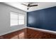 Empty bedroom with hardwood floors, ceiling fan, and a navy blue accent wall at 2015 N College Ave, Indianapolis, IN 46202