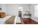 Bright bedroom with modern decor, hardwood floors, and a glimpse of an updated ensuite bathroom at 2015 N College Ave, Indianapolis, IN 46202