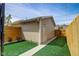 A well-maintained backyard featuring a detached garage, artificial turf, and wood fencing for privacy at 2332 Central Ave, Indianapolis, IN 46205