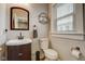 Bathroom featuring a decorative mirror, white toilet, and white sink on a dark wood vanity at 2332 Central Ave, Indianapolis, IN 46205