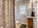 Cozy bathroom with a vanity, toilet, and patterned shower curtain, providing a functional and private space at 2332 Central Ave, Indianapolis, IN 46205