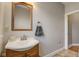 Bathroom featuring a vanity with a sink, a wooden-framed mirror, and warm lighting for a comfortable space at 2332 Central Ave, Indianapolis, IN 46205