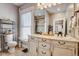 Bathroom with double sink vanity, decorative mirror, and window with blinds, offering a bright and functional space at 2332 Central Ave, Indianapolis, IN 46205