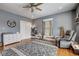 Spacious bedroom with hardwood floors, a ceiling fan, and a comfortable armchair at 2332 Central Ave, Indianapolis, IN 46205