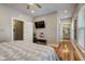 Bedroom with an en-suite bathroom, a television, hardwood floors, and a ceiling fan at 2332 Central Ave, Indianapolis, IN 46205
