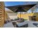 This fenced patio features a large patio umbrella, gas firepit, outdoor table and a sectional sofa at 2332 Central Ave, Indianapolis, IN 46205