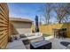 This fenced patio features a large patio umbrella, gas firepit, outdoor table and a sectional sofa at 2332 Central Ave, Indianapolis, IN 46205